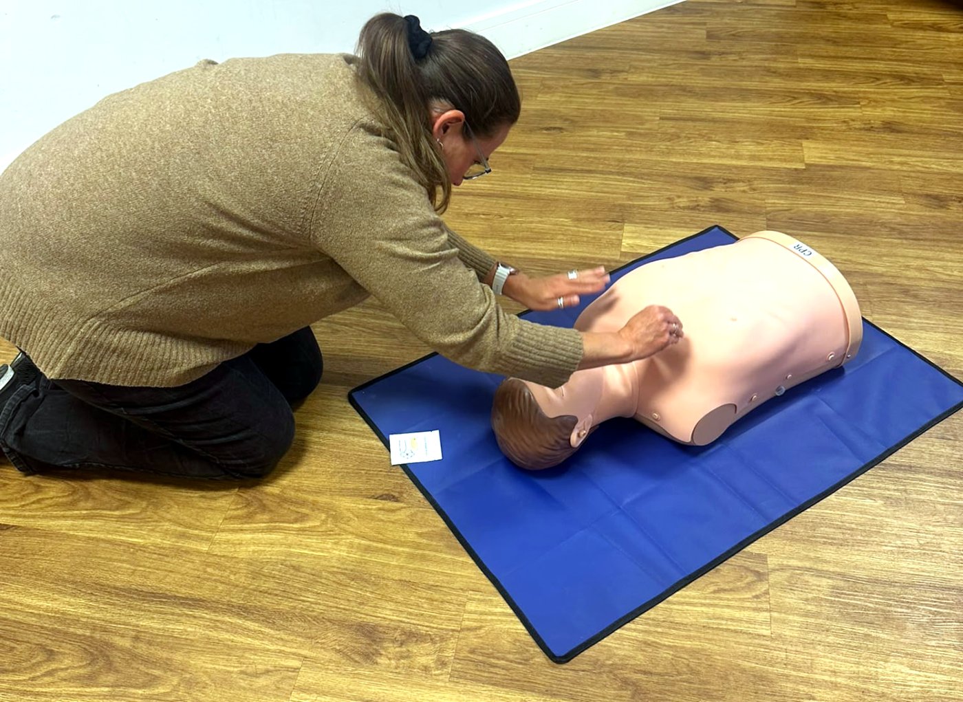 Learner checking a manikin for breathing
